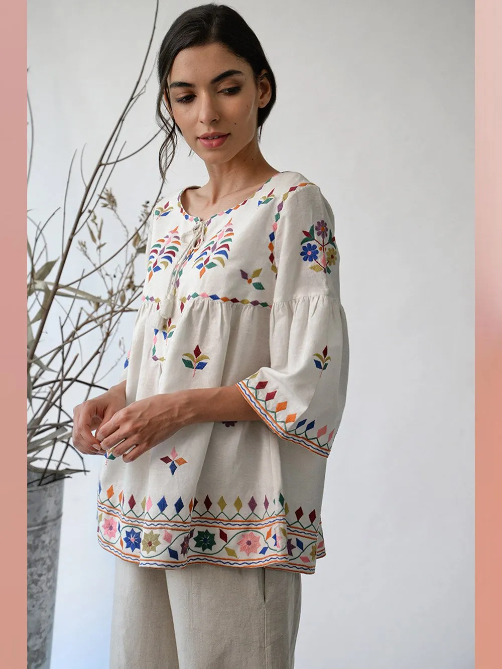 UMBAR by Payal Pratap   I   Top Mandvi  I  A Round Neck Tassle Tie Up Top With Peplum Sleeves And Intricate Thread Multicolour Embroideries From The Kutch Region  I  Perfect For Your Summer Day Out As Well As That Beach Getaway